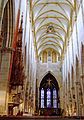 View toward the choir showing the ancient glass in the apse and the wooden filigree canopy of the nave pulpit