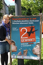 Katharina Schulze präsentiert das Plakat zum Bürgerentscheid über die Dritte Startbahn am Münchner Flughafen