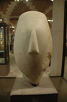 Cabeza d'una figura de muyer (periodu cicládicu, 2700–2300 e.C.). 27 cm. Muséu del Louvre, París.