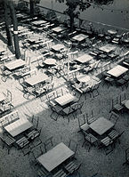 Restaurant terrace, vintage print, ferrotypizovaný bromostříbrný želatinový tisk na papíru chamois; rozměr: 24,5 x 18 cm. Fotografovo razítko Foto H. Koch Halle/S. a anotace tužkou na rubu snímku. Mezi lety 1929 a 1932.