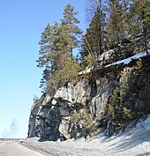 Foto einer Straße, die an einer Felswand vorbeiführt