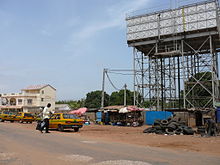 A road with a few taxis and a box water tower