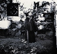 1869年，John Thomson在北京拍摄的，穿着宽大旗装的女性，她的二把头装饰简单，脑后造型呈八字型。