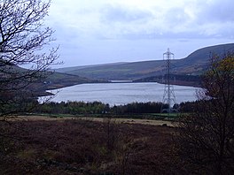 A tree framed shot of a reservoir with hills on either side