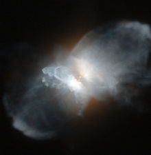 Nebulosa com um brilho central de onde irradiam dois lóbulos de gás