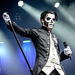 Offentlig Papa Emeritus III Svart finrock med öppen front och silvrig ghostkrucifix på vänster bröst, vit heltäckande innerväst med framskört, svarta byxor, och vita handskar.