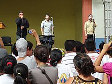 Three men singing in a concert.