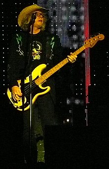 Mills playing bass guitar and singing