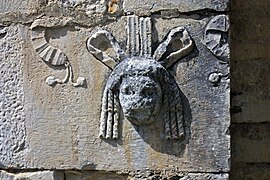 Masque de théâtre en remploi à l'extérieur de la basilique Saint-Just de Valcabrère.