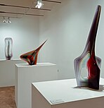 Tres esculturas de vidrio de la serie Abstracción Cromática. Se encuentran en posición diagonal la una con respecto a la otra y se han empleado diversos colores para el vidrio