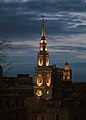 An evening view of the building's illuminated steeple