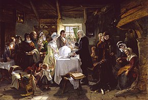 A group gathered around a table where a minister sprinkles water on the head of an infant held by a man. Baptism in Scotland by John Phillip