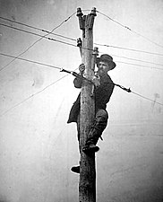 A man cuts telegraph wire to slow communication.