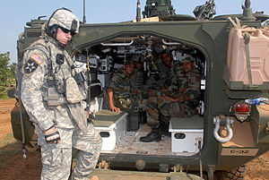 «Страйкер», вид со стороны кормы. Откидная аппарель. Штабс-сержант Джереми Рейнольдс из 2-й бригады 2-й пехотной дивизии с индийскими солдатами в ходе учений с индийской армией Yudh Abhyas, 14 октября 2009 года.