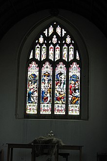 Picture of the stained glass window gifted by Hill to Axbridge parish church after its restoration in 1887. Four lights are shown representing Nativity, Crucifixion, Resurrection, and Feed my Lambs