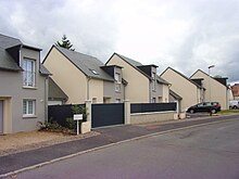 Photographie en couleurs d'une succession de maisons mitoyennes construites sur le même modèle.