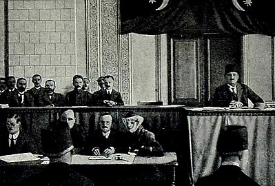 משלחת אזרבייג'נית בפריז במלון Claridge במהלך ועידת השלום בפריז, 1919. דגל הטריקולור של הרפובליקה נראה ברקע, על שידת המגירות.