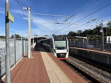 An electric multiple unit train departing from a station's platform