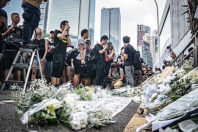 Les fleurs en hommage à Ling-Kit Leung sur le trottoir du Queensway