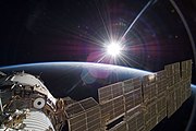 Sunrise in orbit overlooking Zvezda and its solar array