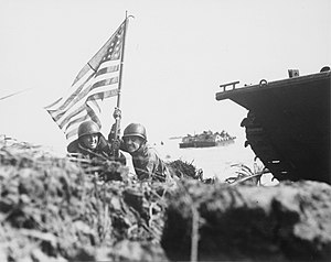Два морських піхотинці США (капітан Пауль О'Ніл (зліва), капітан Мілтон Томсон) ставлять американський прапор на острові Гуам, через вісім хвилин після висадки на острові.