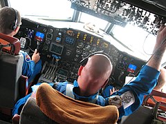 画像左端のパイロットが操縦している状態。眼は窓の外や計器を見て自機の状態などを把握。耳にはヘッドセットをつけ、管制官などとの交信を行う。手は操縦桿を握る。足はペダルを操作する。（NOAA所属機にて）