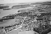 Flyfoto av Nøtterøy sett fra nordøst, trolig tatt på 1950-tallet, viser Teie foran, Føynland i bakgrunnen og del av fjordbassenget Træla til venstre. Foto: Widerøe/Vestfoldmuseene