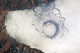 Cirklo de fajna glacio, diametro de 4.4 km ĉe la suda pinto de la lago, probable kaŭzita per konvekcio
