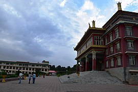 Three-story Tibetan-style building, with people outside for acale
