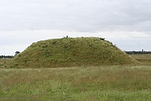 Un tertre de forme allongée recouvert d'herbe.