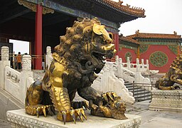 Un león guardián dorado frente al Palacio de la Longevidad Tranquila.