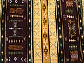 Un tapis kabyle multicolore avec des motifs géométriques.