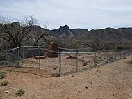 The fenced-in ruins of an adobe hotel in Helvetia.