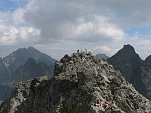 Pohled na nejvyšší skalnaté hřebeny, uprostřed vrchol s turisty