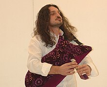 Man with long hair and bagpipe