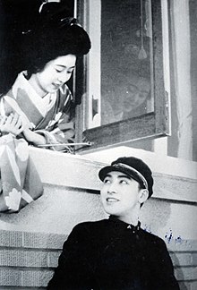Japanese woman looking outside the window at a man