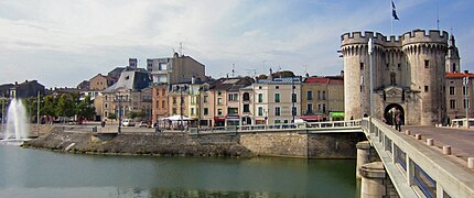 Pont enjambant un fleuve et porte de remparts au bout.