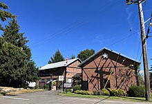 A photo of the Qualicum Beach Museum. The building is made of red bricks and has a grey roof.