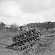 A Sherman tank uses a Churchill Ark to climb an escarpment during a training exercise
