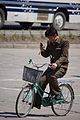 ながら運転の一例。自転車の運転中に携帯電話を手に持ち、画面に意識を向けている。