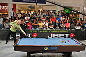 Woman shoots a pool break in mid-air