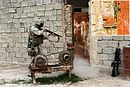 נחת פורץ דלת של בית עיראקי באמצעות רובה צייד על מנת לאפשר כניסה וחיפוש במבנה.