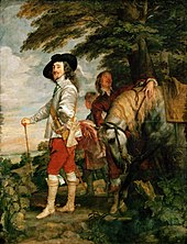 Charles Ier portant une veste grise, un pantalon rouge, des bottes, une canne et un chapeau noir et une tenue d'équitation se tient sous un arbre aux côtés d'un cheval et de son écuyer.
