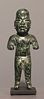 An "elongated man" figurine, dark green serpentine.