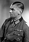 Black-and-white portrait of a man in semi profile wearing a military uniform with an Iron Cross displayed at his neck.