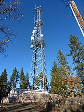 Tall steel lattice structure with three platforms and various transmitting equipment