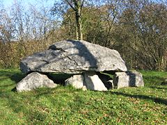 Photo d'un dolmen au centre d'une pelouse.
