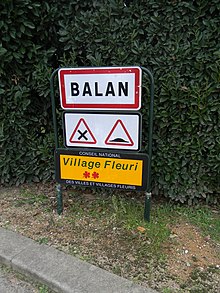 Photographie du panneau « deux fleurs » à l'entrée de Balan.