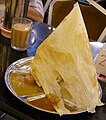 Image 66Roti tisu served as a savoury meal, pictured here with a glass of teh tarik. (from Malaysian cuisine)