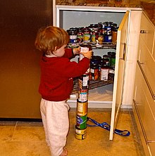 Photograph of a child with autism stacking cans.